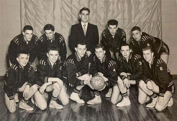 The 1951-52 basketball team posing in their uniforms with coach Bill Farrell